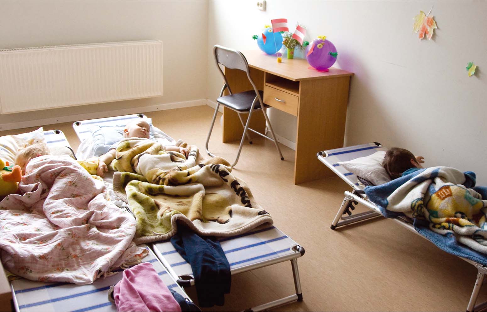 Pusdienas snaudā aizmiguši slimnīcas darbinieku bērni, kam te ierīkota rotaļu grupiņa