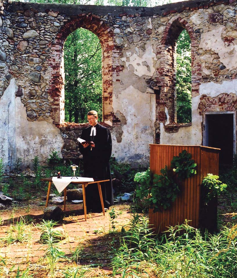 Mācītājs Juris Rubenis vada dievkalpojumu Ģipkas baznīcas drupās, 1995. gads
