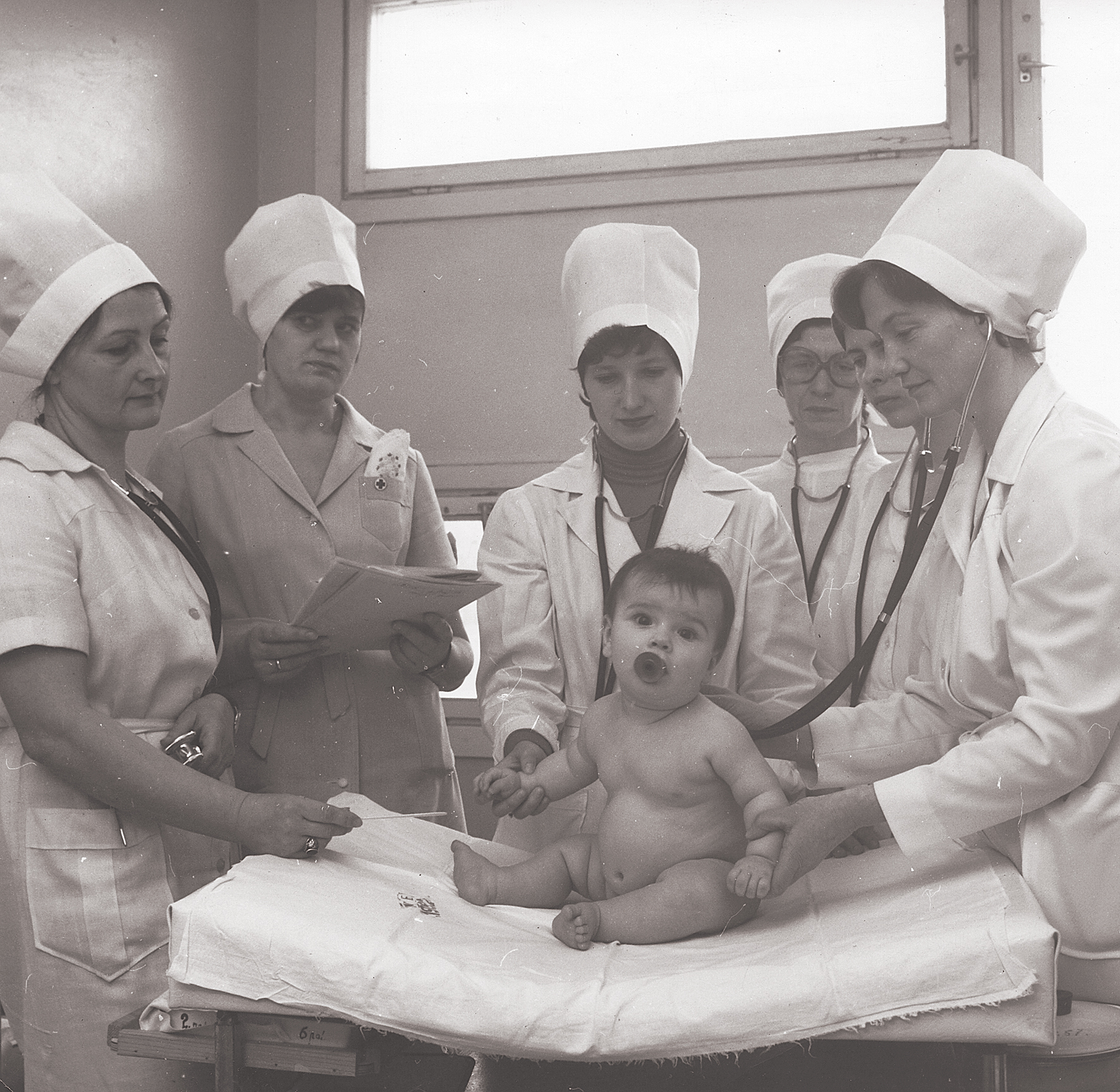 Topošā pediatre (attēla centrā)  kopā ar Bērnu klīniskās universitātes  slimnīcas mediķiem izmeklē  mazo pacienti. 1983. gads